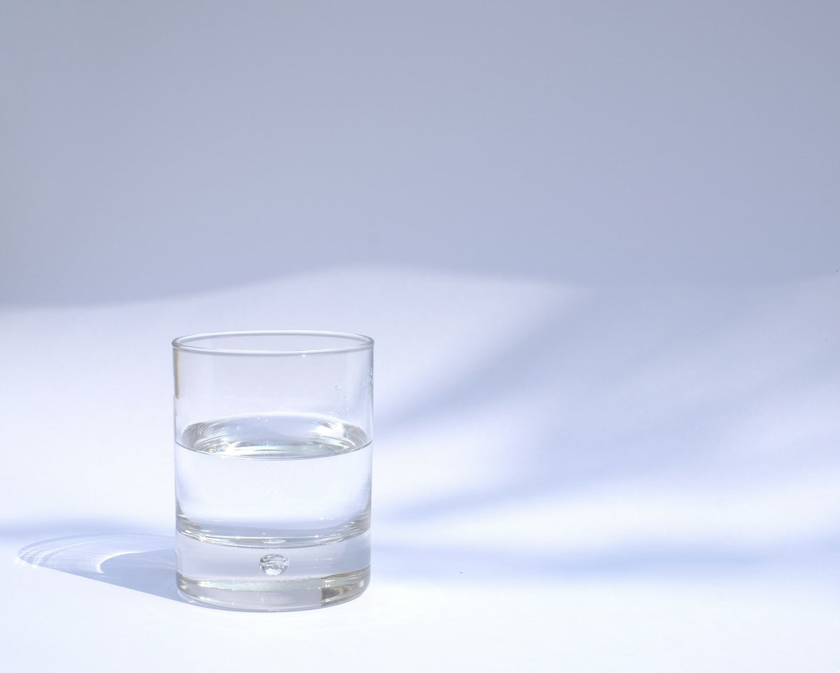 Glas helder water op een lichte achtergrond – wateranalyse en reservering waterbehandelingsset