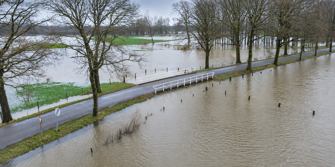 Bewerkte illustratie van wateroverlast in een laaggelegen landschap